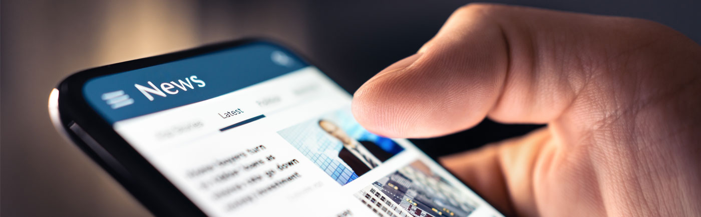 A man scrolling through a newsfeed on his phone