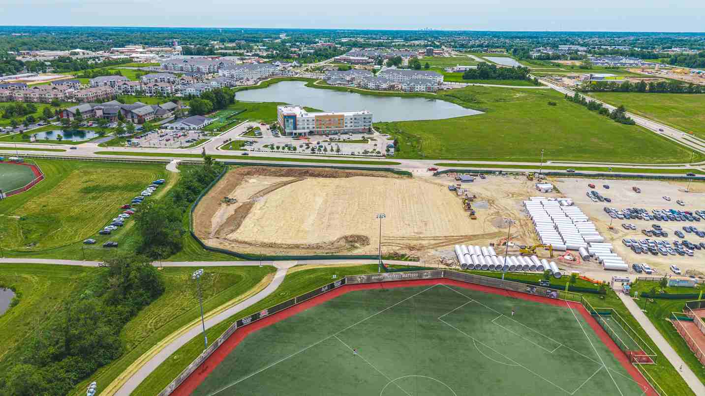 Aerial view of development site with sports field and nearby residential area